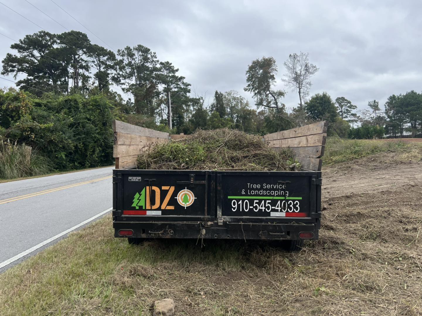 Commercial Site Clean up tree branches loaded into a dump trailer from a commercial site clean up
